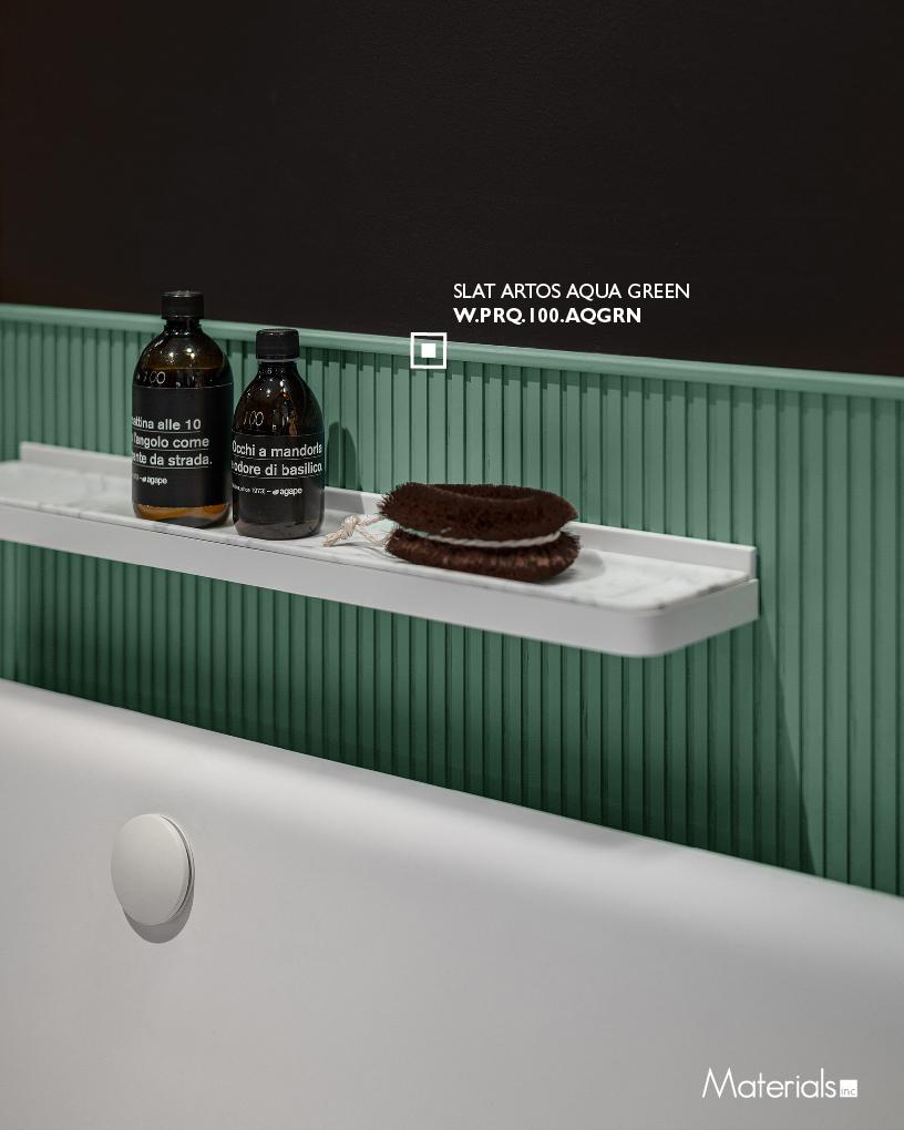 Slat Artos Aqua Green fluted wall panel behind a floating bathroom shelf, wider view including the tub rim