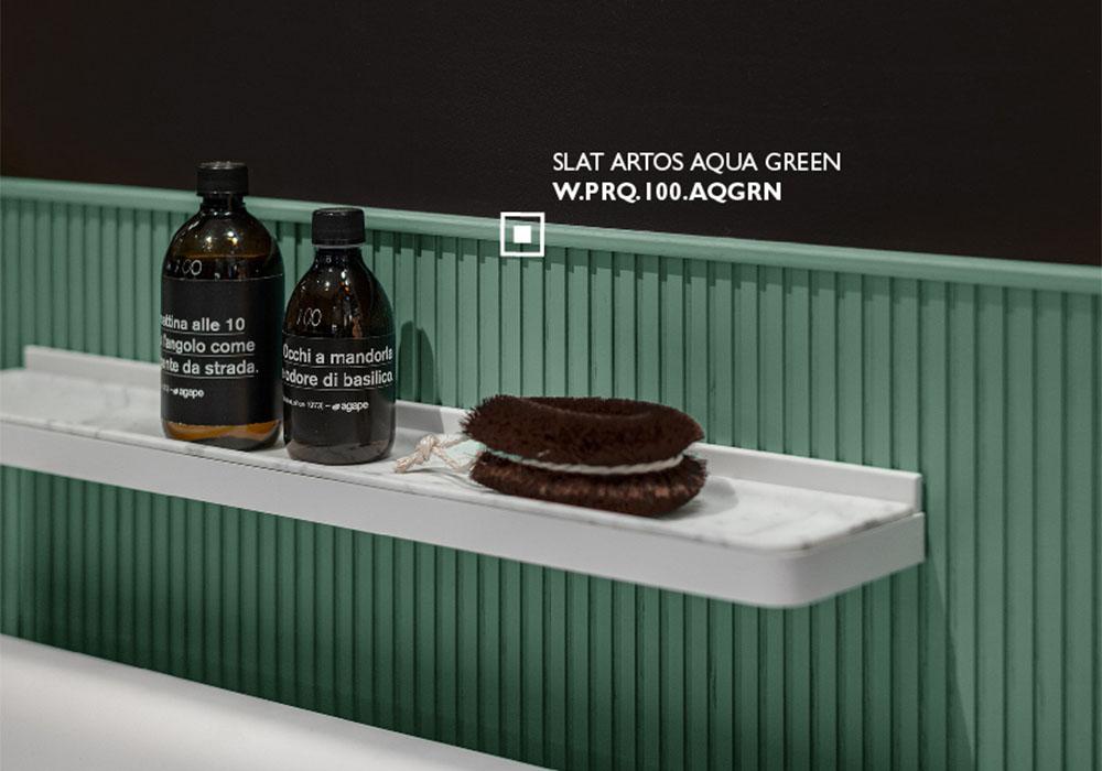 Slat Artos Aqua Green fluted wall panel behind a floating bathroom shelf with amber glass bottles