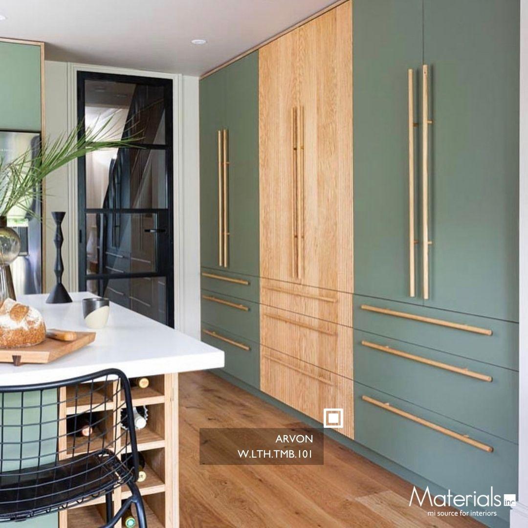 Tambora Arvon milled wood panel on a tall cabinet door in a sage green kitchen with brass hardware