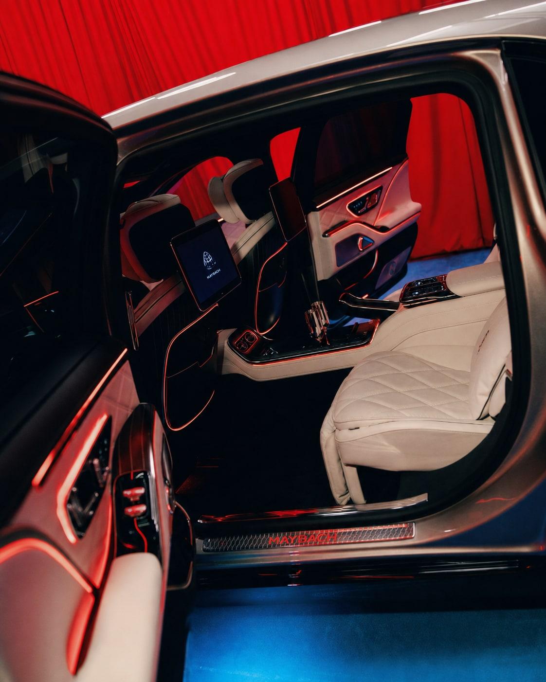 Open rear door of the Maybach showing Koncepts veneer trim, ivory quilted leather seats and red ambient lighting
