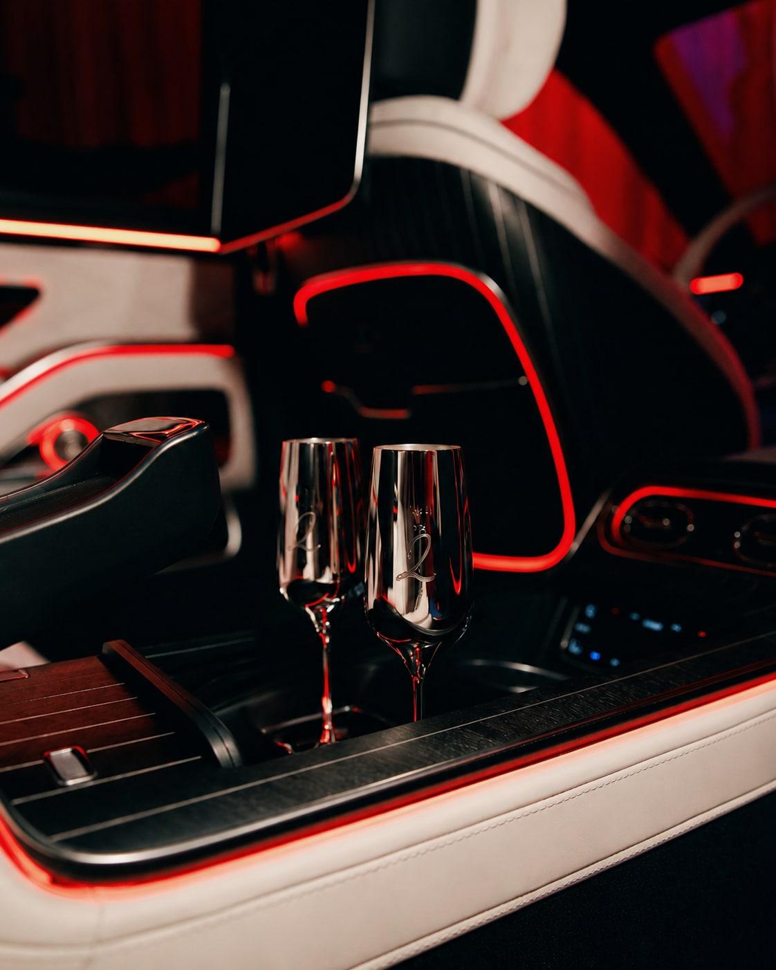 Koncepts veneer console in the Maybach rear cabin with two silver champagne flutes and red ambient lighting