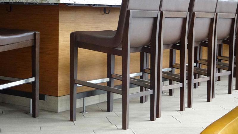 Prensa embossed wood panel cladding a hotel bar counter facade