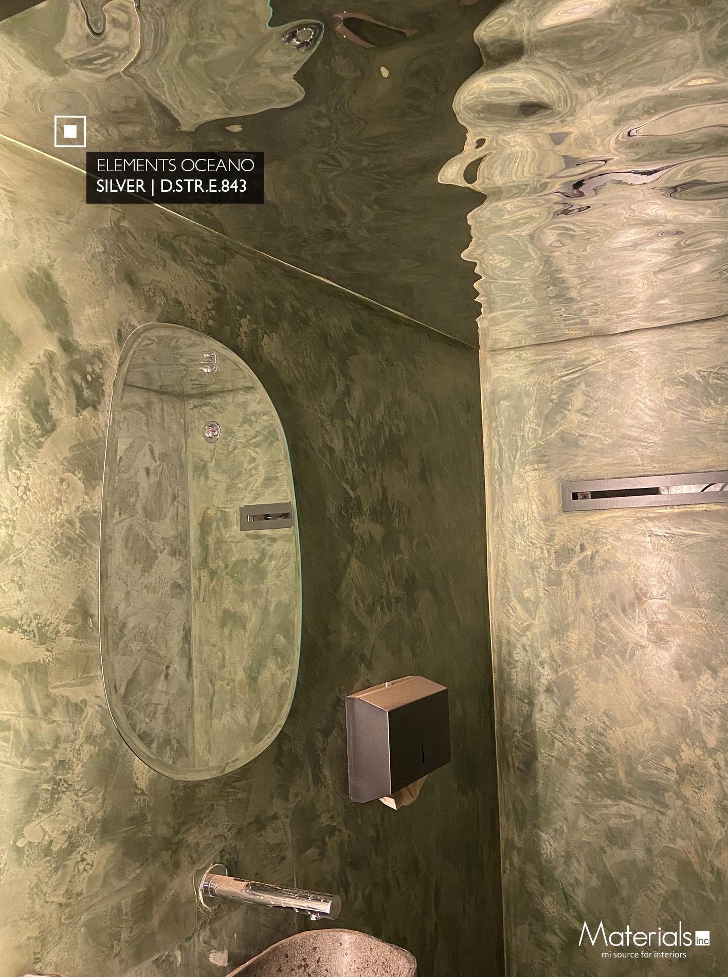 Elements Oceano Silver metallic laminate cladding a bathroom wall and ceiling around an oval mirror