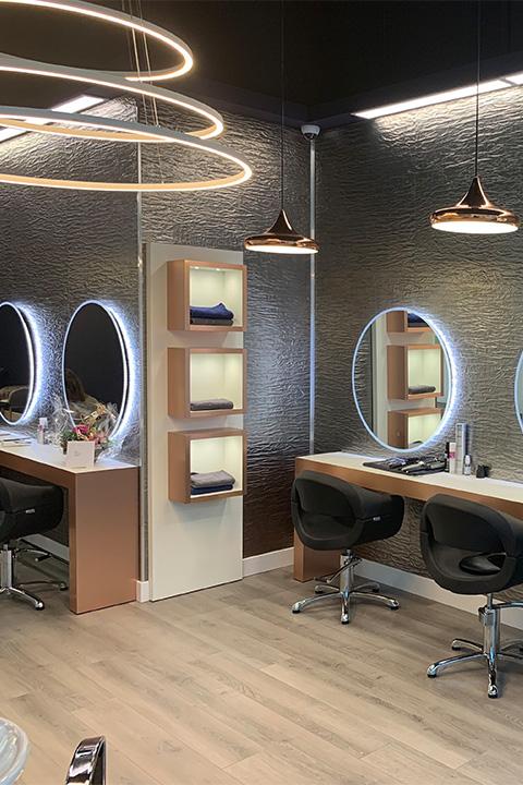 Elements Texture Silver Distortion laminate cladding a hair salon wall between backlit round mirrors