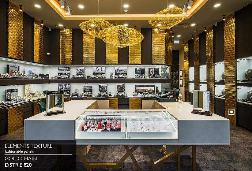 Elements Texture Gold Chain laminate cladding pillars in a jewelry boutique beneath gold mesh pendant lights