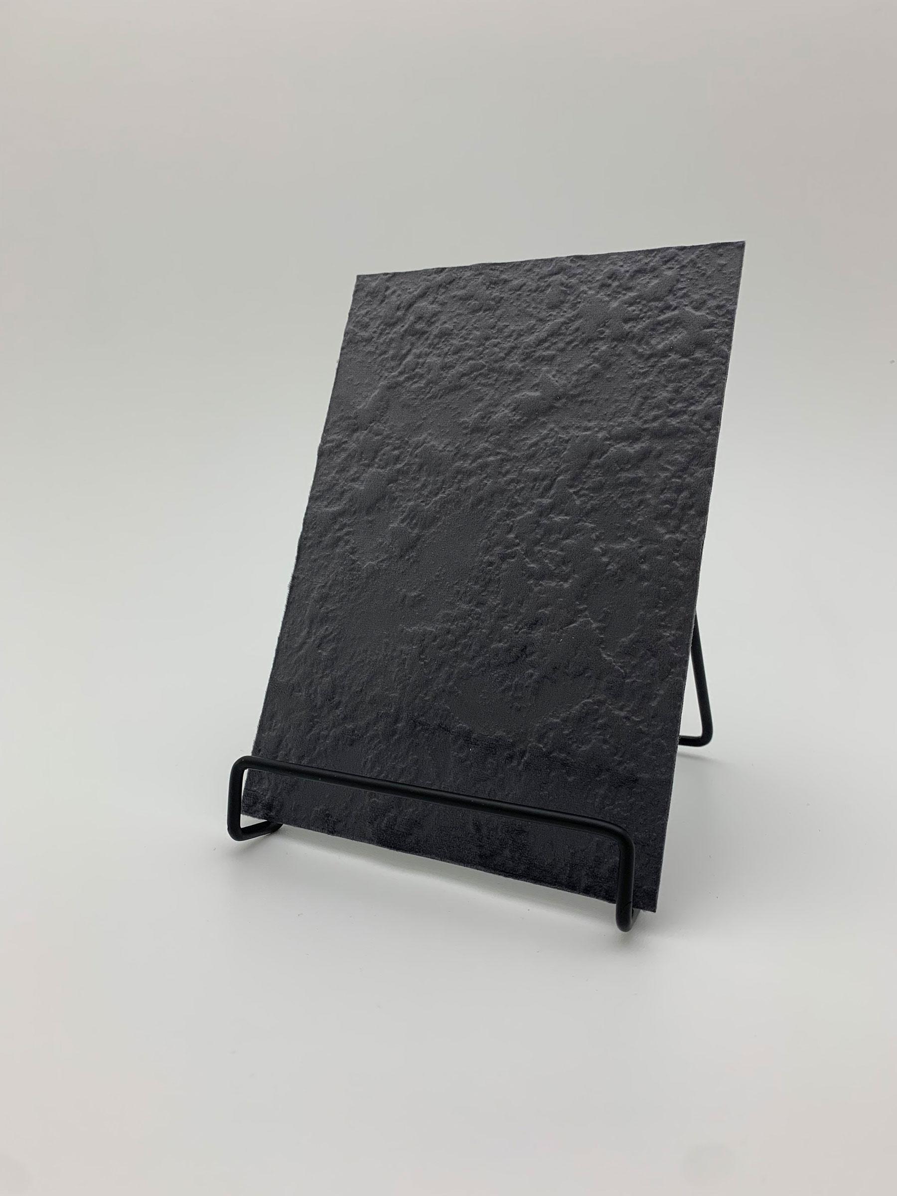 Elements Velvet Molten Ash real material sample - a rippled, molten-looking velvet surface in charcoal