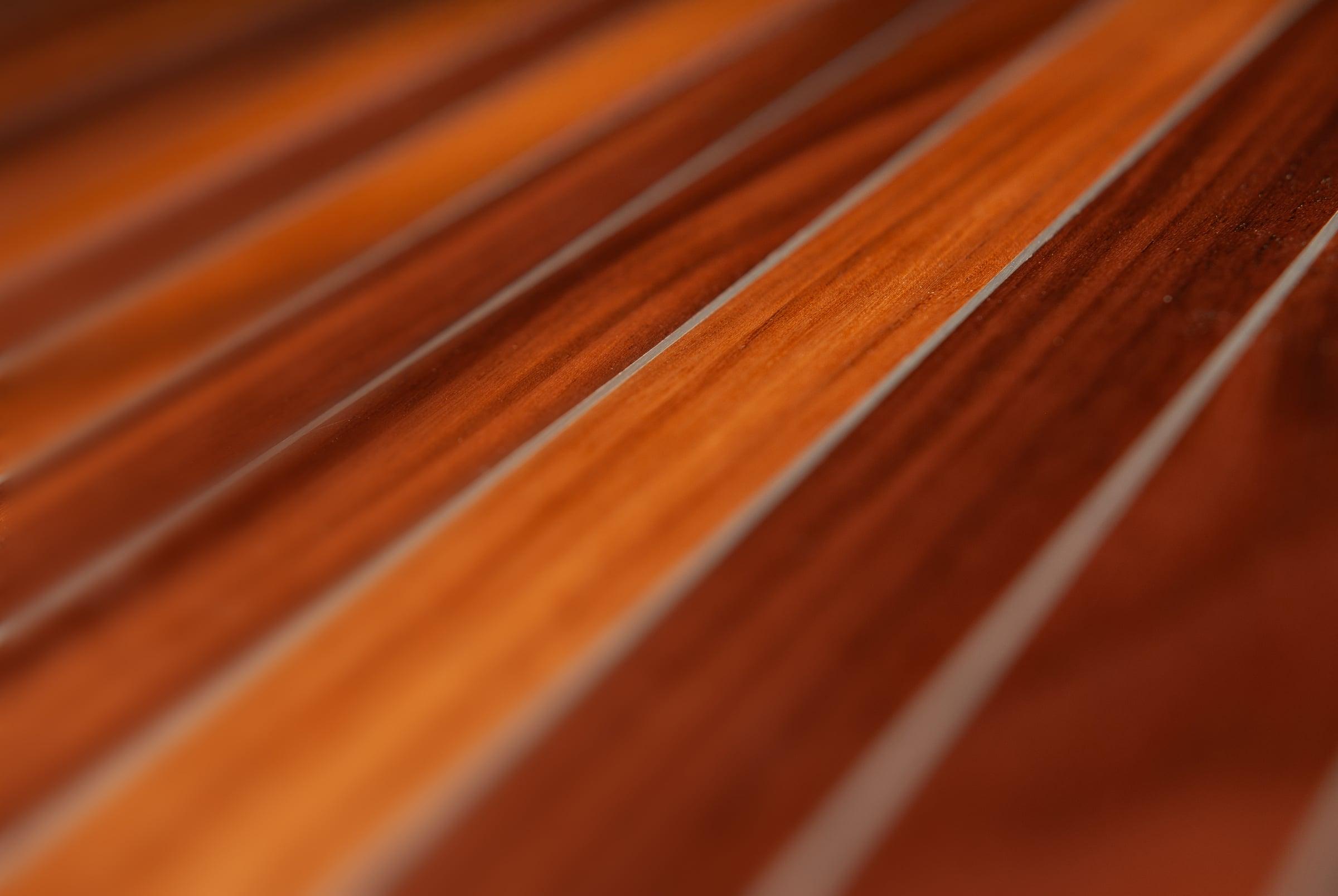 Koncepts Walnut Stripes close-up - metal inlay lines catching the light across walnut veneer