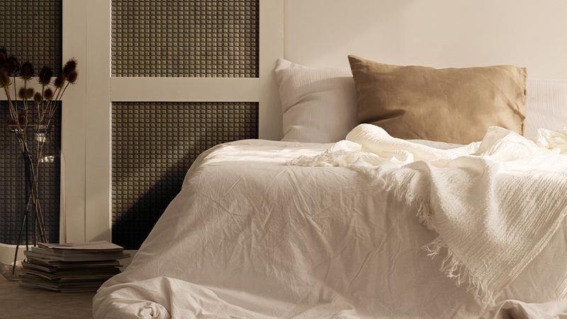 Elements Texture laminate with a woven metallic finish behind a bedroom headboard