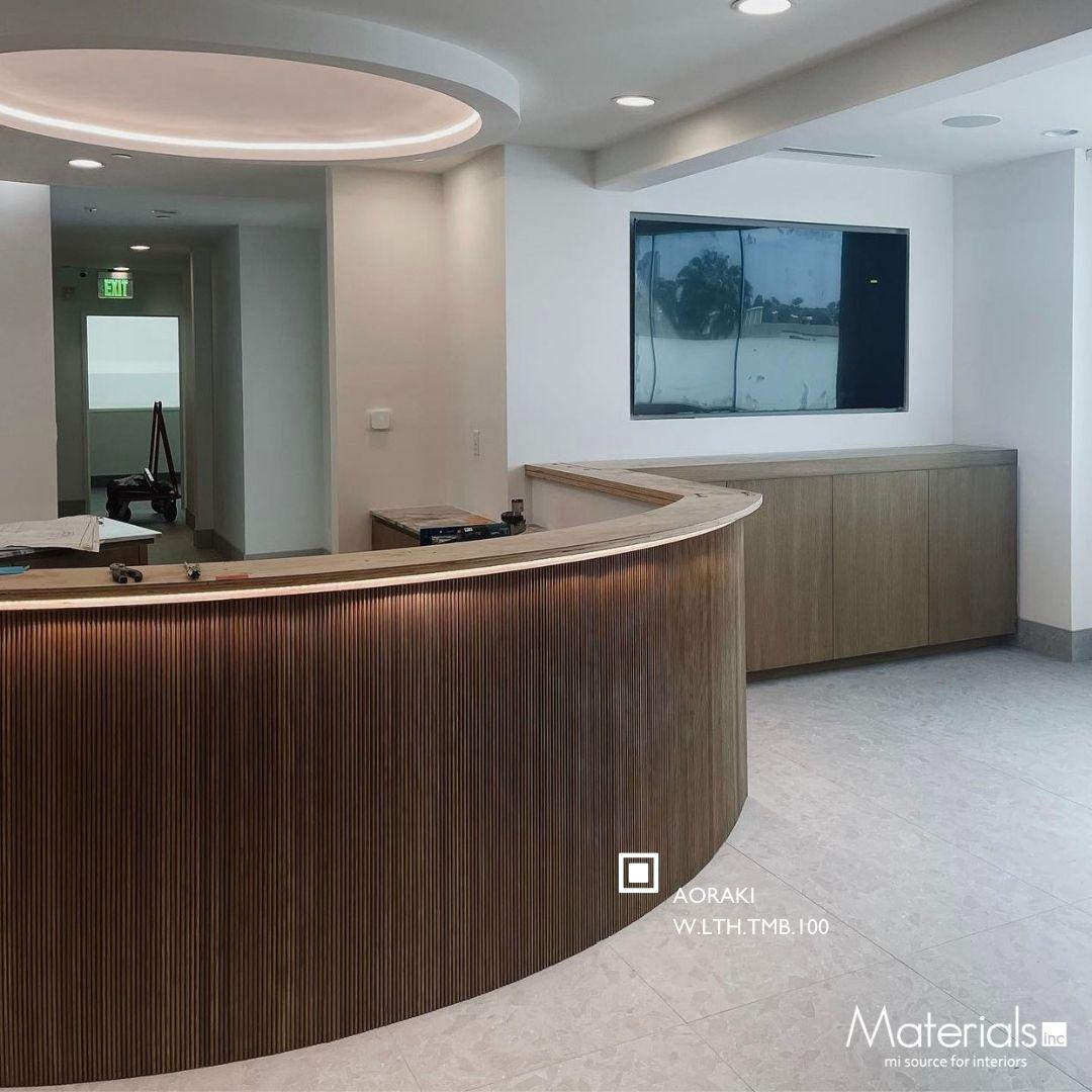 Tambora Aoraki milled wood panel on a curved office reception desk