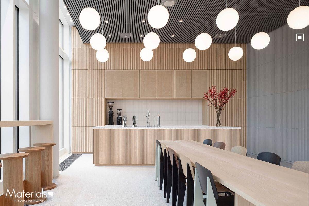 Aria Fluted concrete panel cladding a café breakroom wall beneath globe pendant lights
