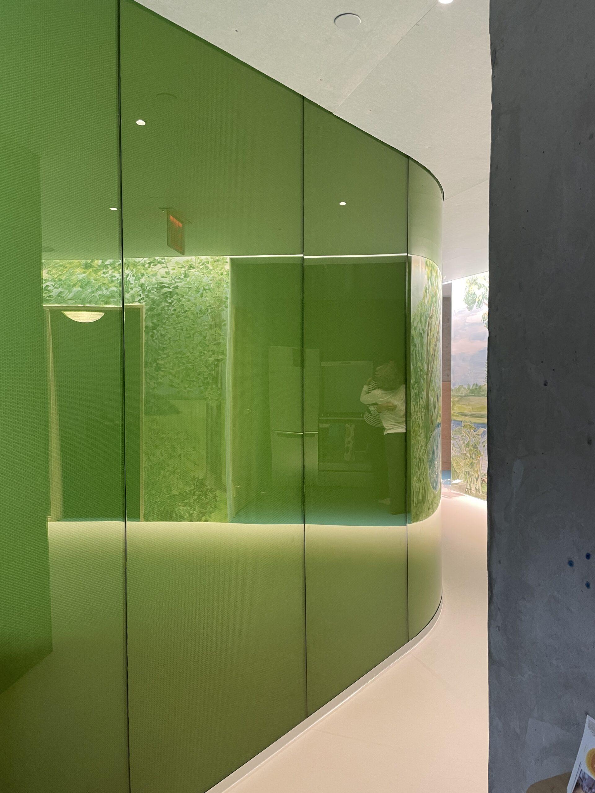 Luminous translucent honeycomb panel forming a curved green partition wall in a children's learning center