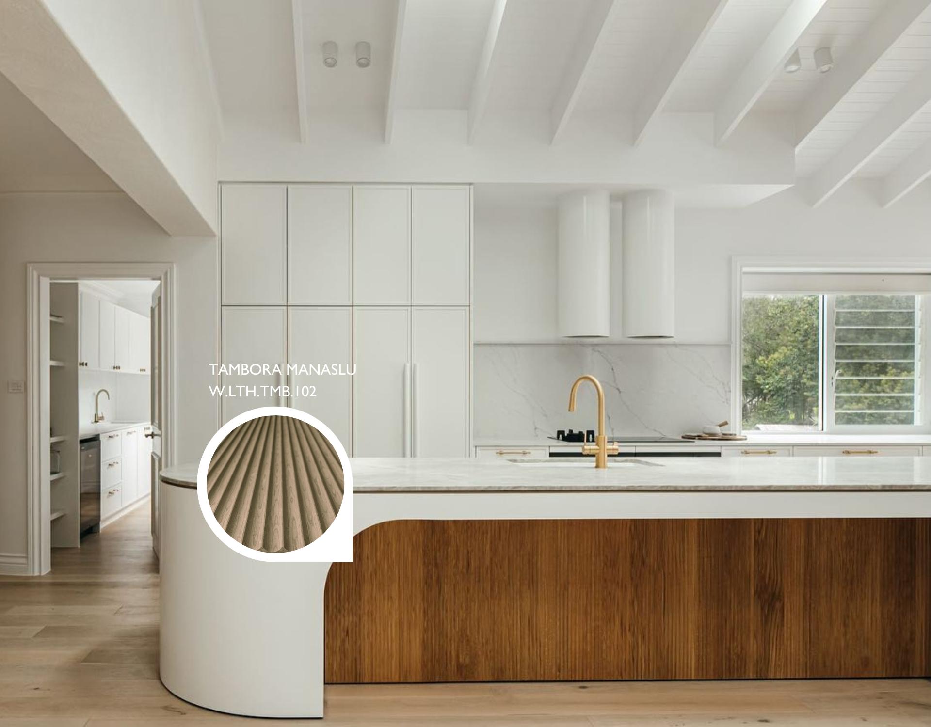 Tambora Manaslu milled wood panel on a curved kitchen island base beneath white cabinetry and gold fixtures