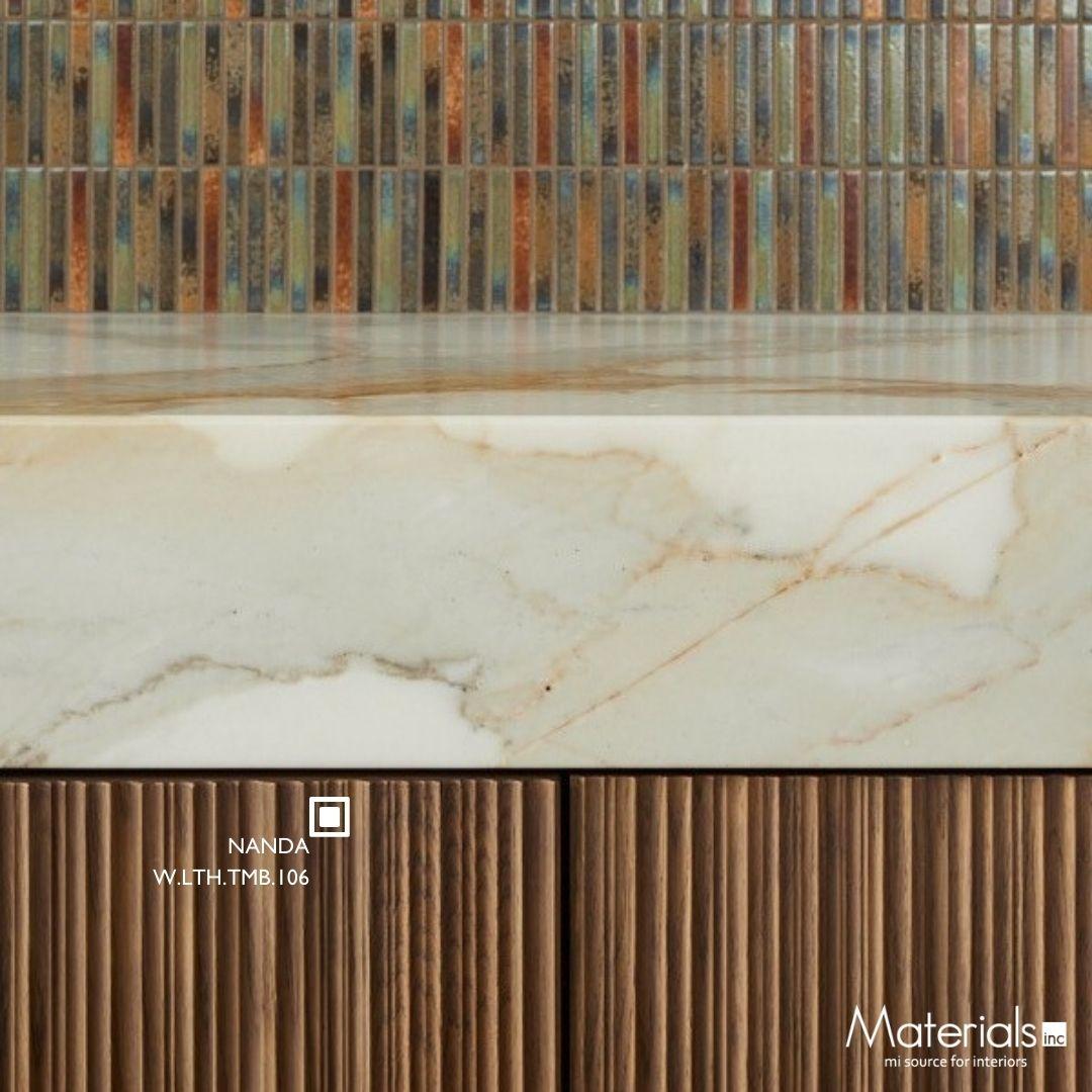 Close-up of Tambora Nanda milled wood panel cabinetry beneath a marble countertop