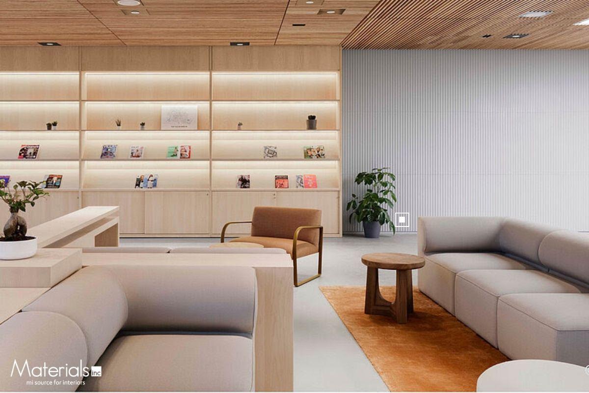 Aria Fluted concrete panel cladding a wall in an office lounge with a bookshelf and orange armchair